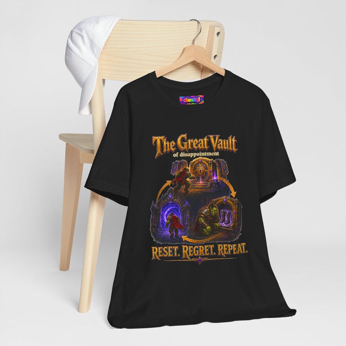 Great Vault Reset Regret Repeat fantasy MMO graphic T-shirt, black shirt hanging beside a chair.